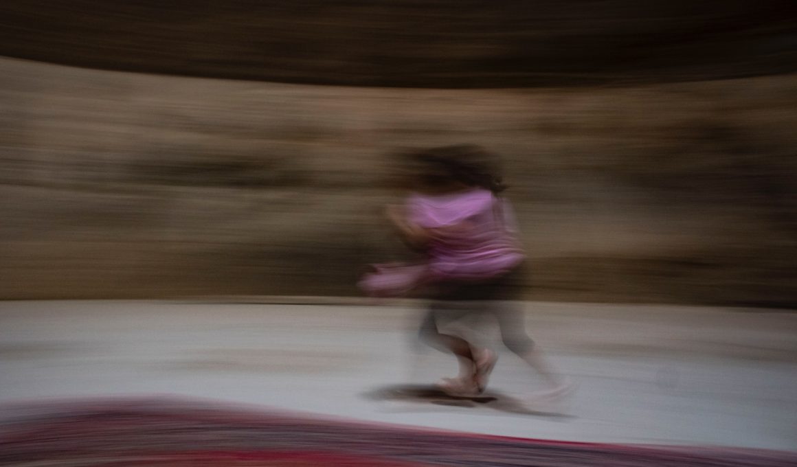 girl in pink shirt and pink pants running on track field